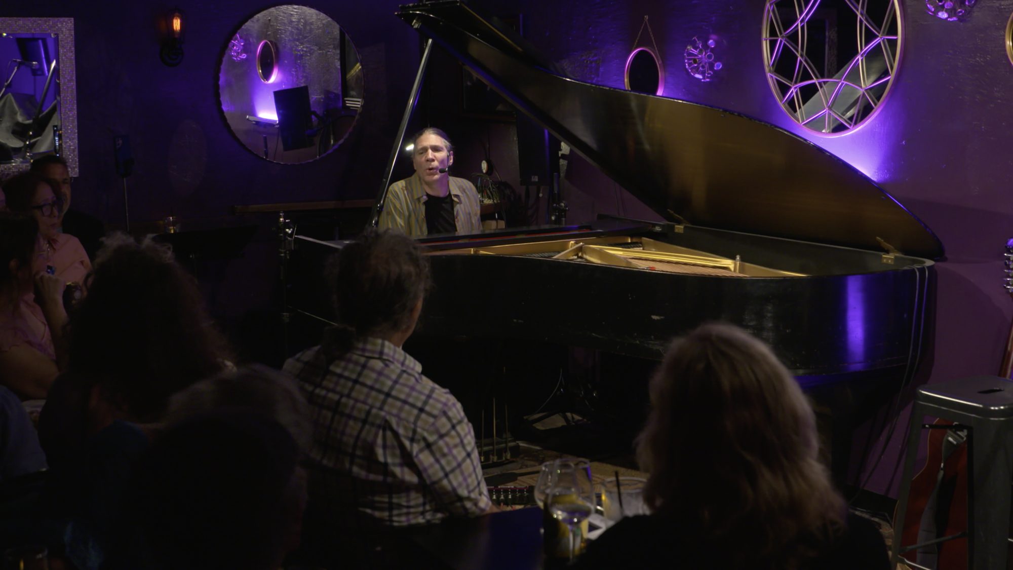 Ernie Savage performing at the grand piano for a listening-room audience